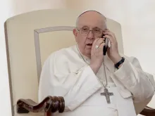 Pope Francis takes a telephone call during the May 17 General Audience.