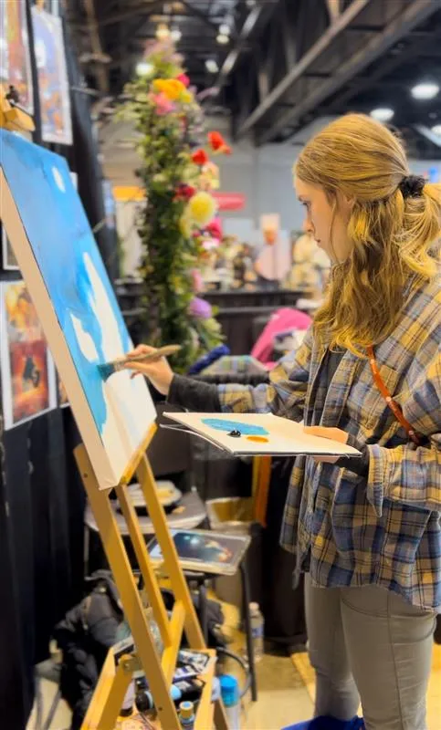 Catholic mural artist Mattie Karr at work. The Kansas-based artist quit her job to revitalize her parish by painting two 15-foot-tall triptychs of the descent of the Holy Spirit and the presentation of Jesus with parishioners as the subjects. Credit: Courtesy of Mattie Karr