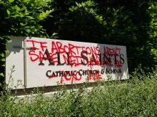 Grafitti on a sign for All Saints Catholic Church in Portland, Oregon, June 25, 2022.