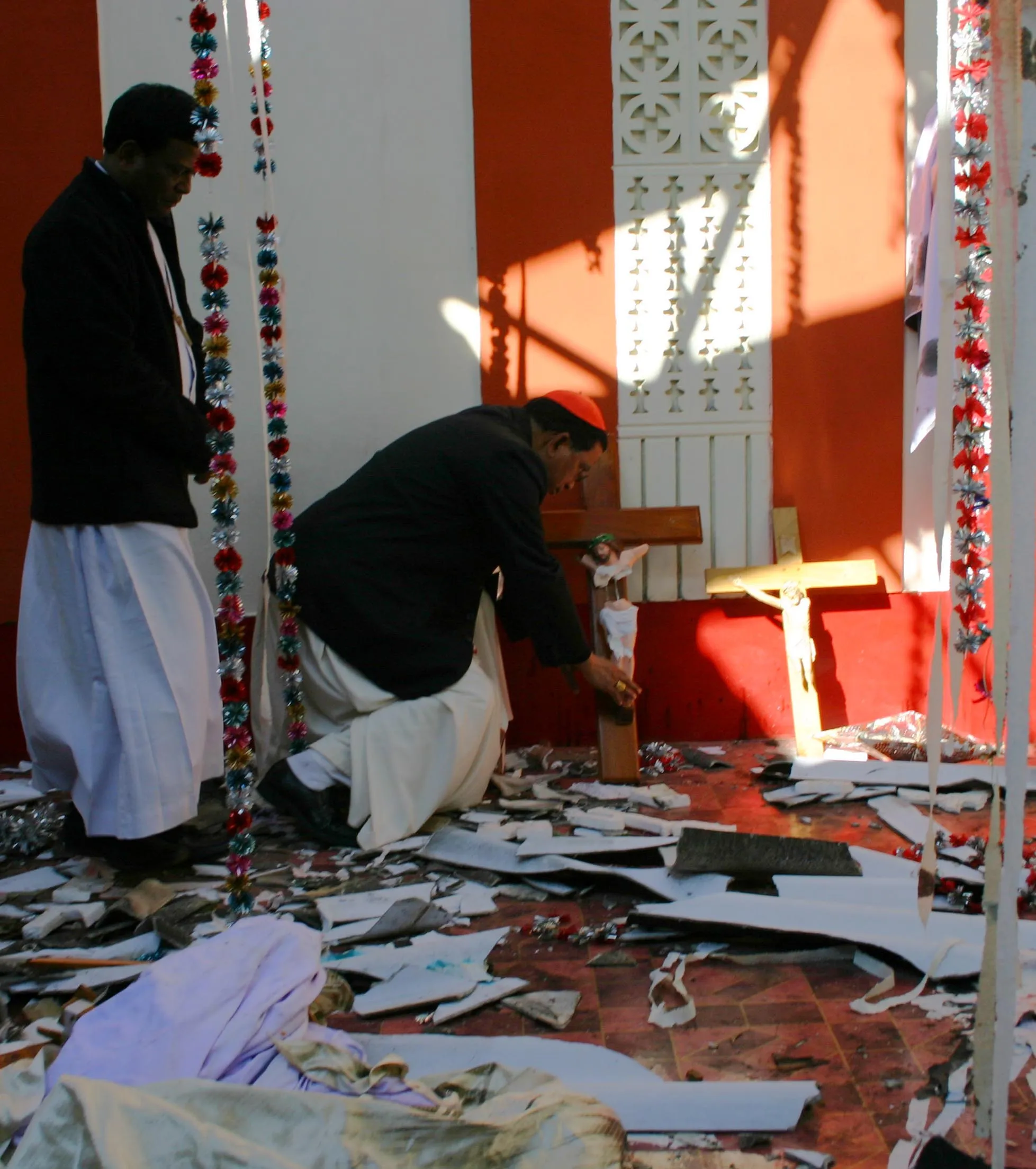 Cardinal Toppo kneels before abroken cross at Sarsananda church in Kandhamal in January 2008.