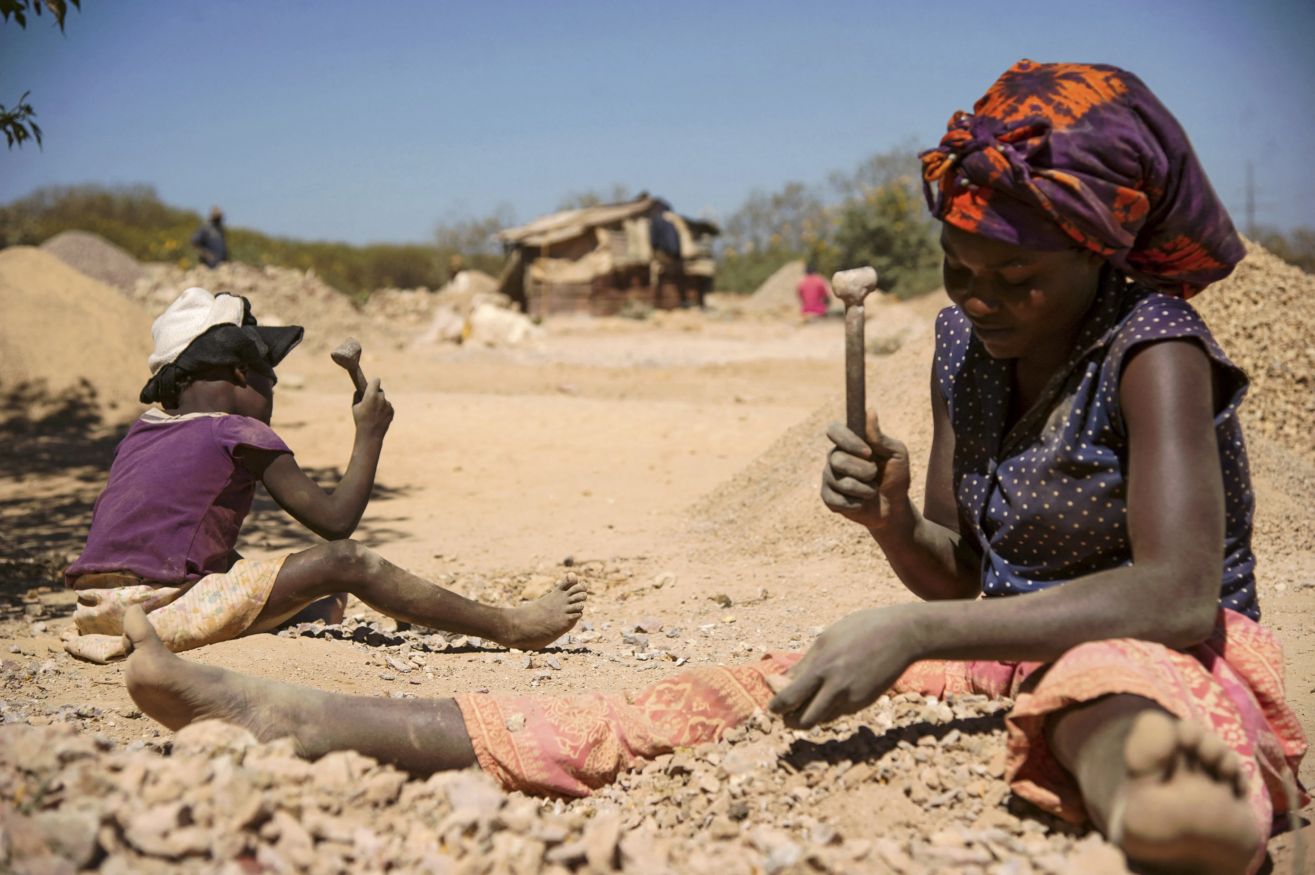 A child and a woman break rocks extracted from a cobalt mine at a copper quarry and cobalt pit in Lubumbashi on May 23, 2016. Junior Kannah/AFP via Getty Images