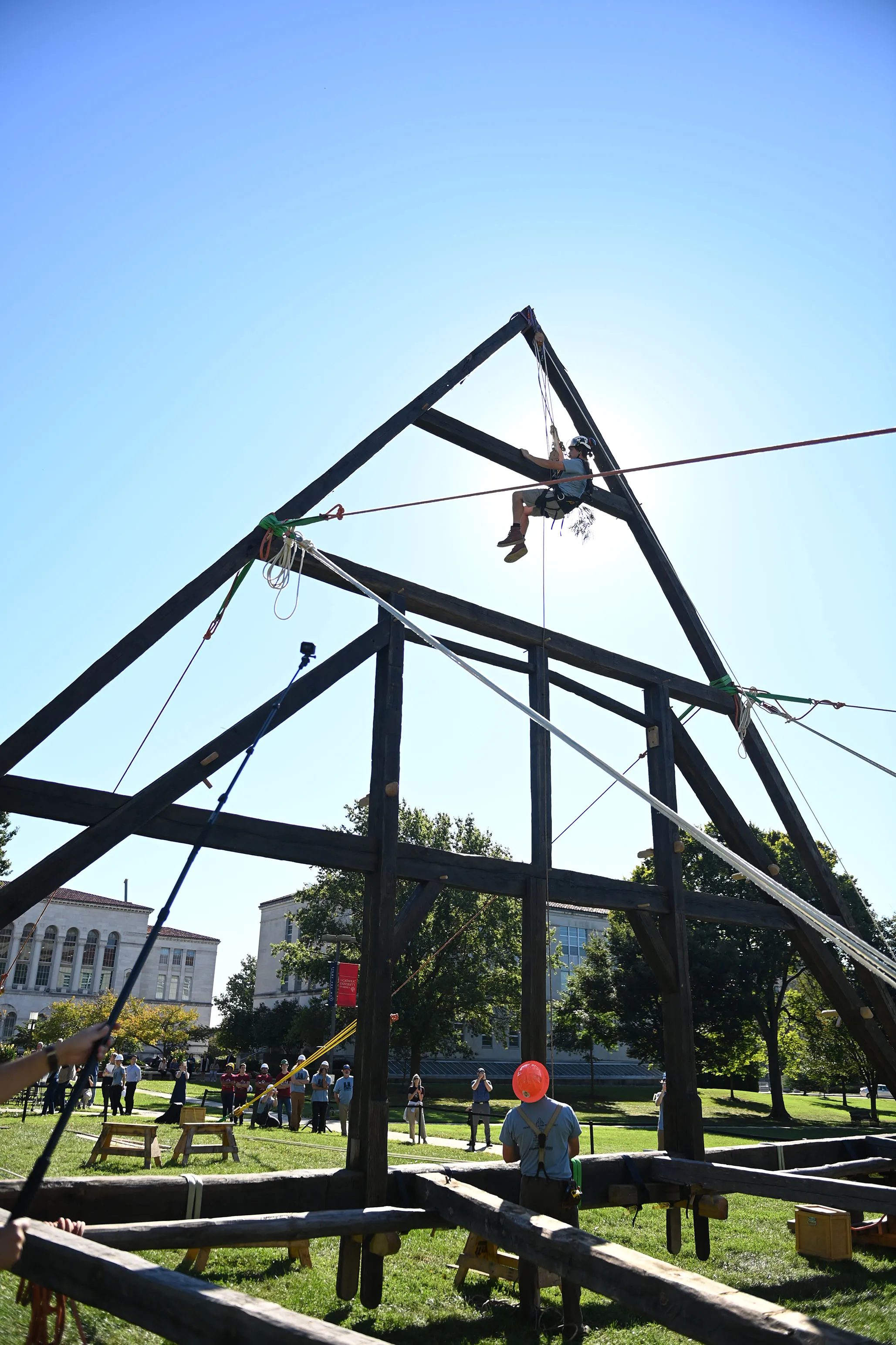A builder climbs the replica Notre-Dame de Paris truss to secure a sharp, or evergreen, bush atop in celebration at the Catholic University of America in Washington, DC, September 26, 2022. Patrick G. Ryan
