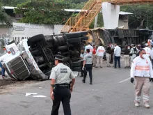 Mexican national guard officers work in the area where a trucked rolled over after a traffic accident that killed migrants from Central America, Dec. 9, 2021 in Tuxtla Gutierrez, Mexico. A truck accident leaves at least 49 people dead and dozens injured according to authorities. Most of the victims are believed to be migrants from Central American who were travelling on a truck that rolled over and crashed into a pedestrian bridge.
