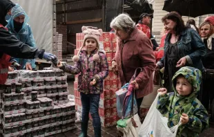 Lybicheva Nina, 72, along with her grandchildren receives food items during a distribution to about 3,000 people by the local branch of Caritas Internationalis, a Catholic charity organization, in Kharkiv, Ukraine, on Sept. 27, 2022. Credit: YASUYOSHI CHIBA/AFP via Getty Images