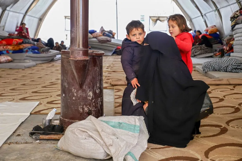 A Syrian woman and her children warm by a stove at an emergency shelter in the center of the city of Maarat Misrin, in the rebel-held northern part of the northwestern Idlib province Feb. 7, 2023, one day after a deadly earthquake hit Syria and Turkey.?w=200&h=150