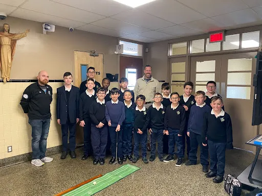 Michael Lubold (left), the custodian at St. Michael's School in Fall River, Massachusetts, and principal Ryan Klein (center) are teaching boys the virtues of being a gentleman in an after-school program call the Young Men's Club. Courtesy of Father Jay Mello