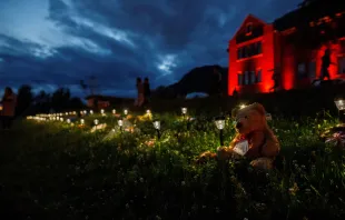 A teddy bear sits beside a lantern outside the former Kamloops Indian Residential School where flowers and cards have been left as part of a growing makeshift memorial created in response to media reports that the "remains" of 215 children have been discovered buried near the facility in Kamloops on June 5, 2021. Cole Burston /AFP via Getty Images