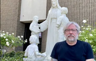 Michael Stucchi poses in front of the restored statue of Jesus with children at St. Mel's Church in Woodland Hills, California. Photo credit: Tom Hoffarth