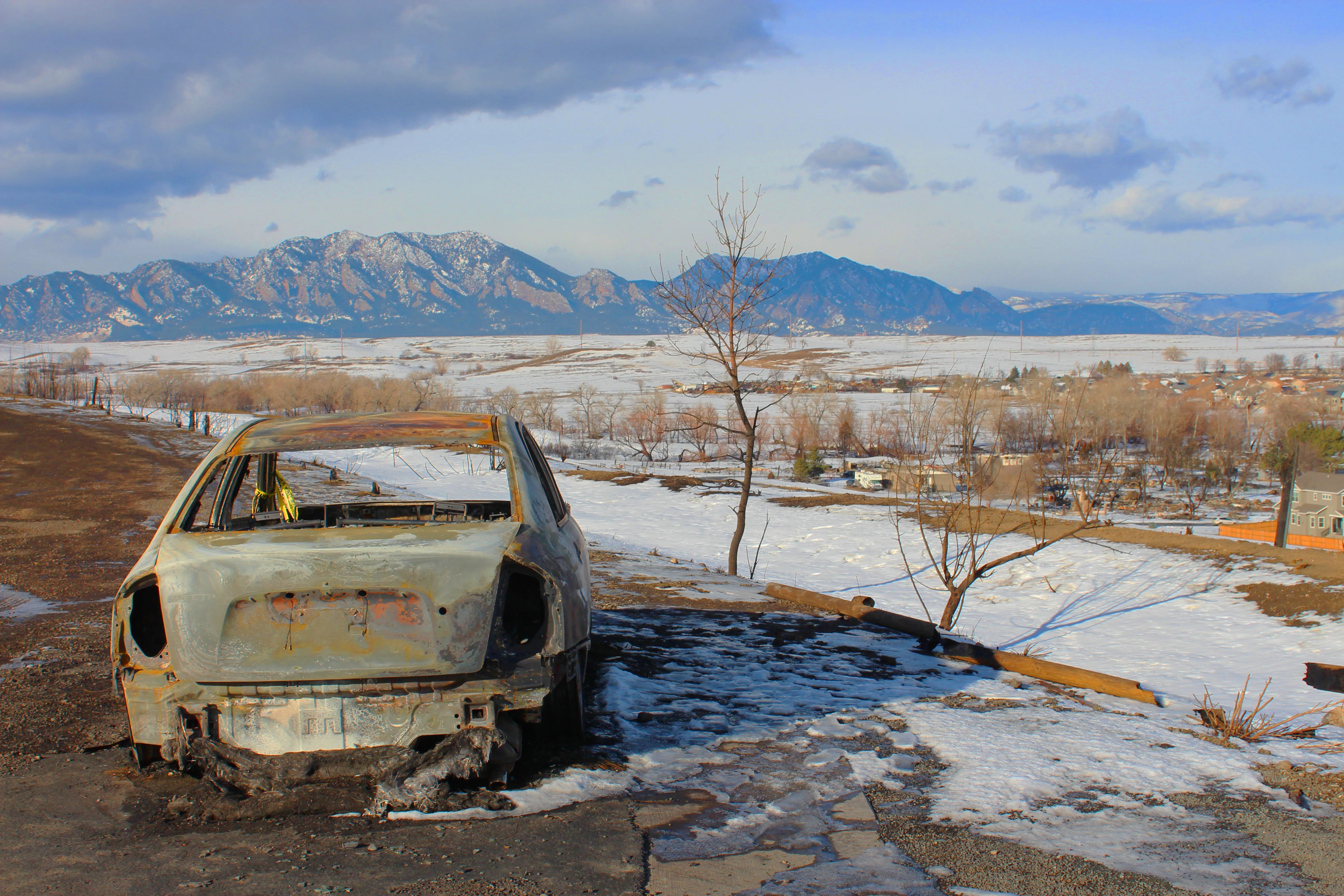 A burned-out car sits at the parking lot of the Oerman-Roche Trailhead, overlooking Superior, Colorado, on Jan. 8, 2022. The fast-moving Marshall Fire burned some 6,000 acres and 1,000 homes in Boulder County beginning on Dec. 30, 2021. Jonah McKeown/CNA