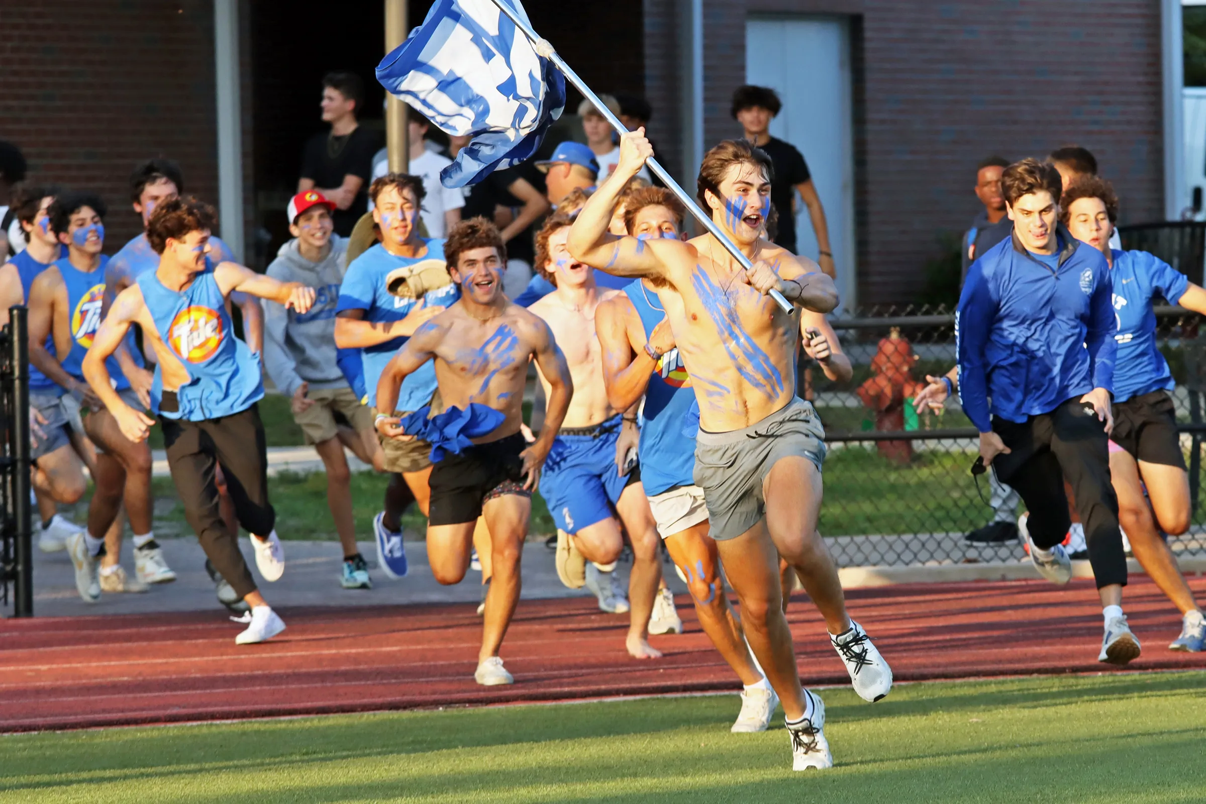 Jesuit High School student fans run out to the bleachers ahead of a football game. Credit: Jesuit High School