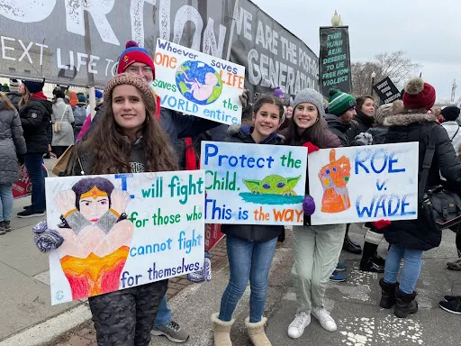 Young adults hold colorful signs outside the U.S. Supreme Court at the March for Life in Washington, D.C., on Jan. 21, 2022.?w=200&h=150