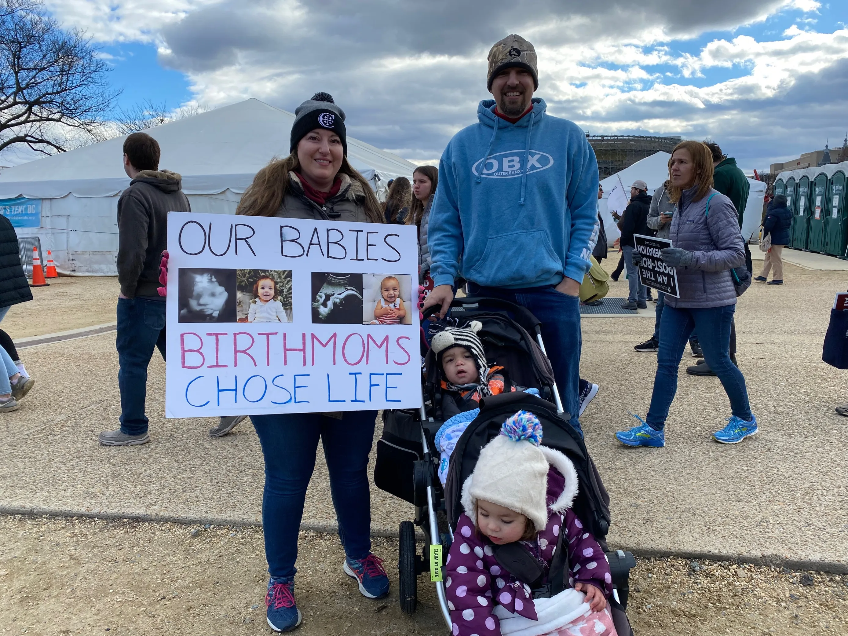 Daniel & Michelle Jacobeen from Alexandria, Virginia, hold a sign that says "Our babies birthmoms chose life.". Katie Yoder