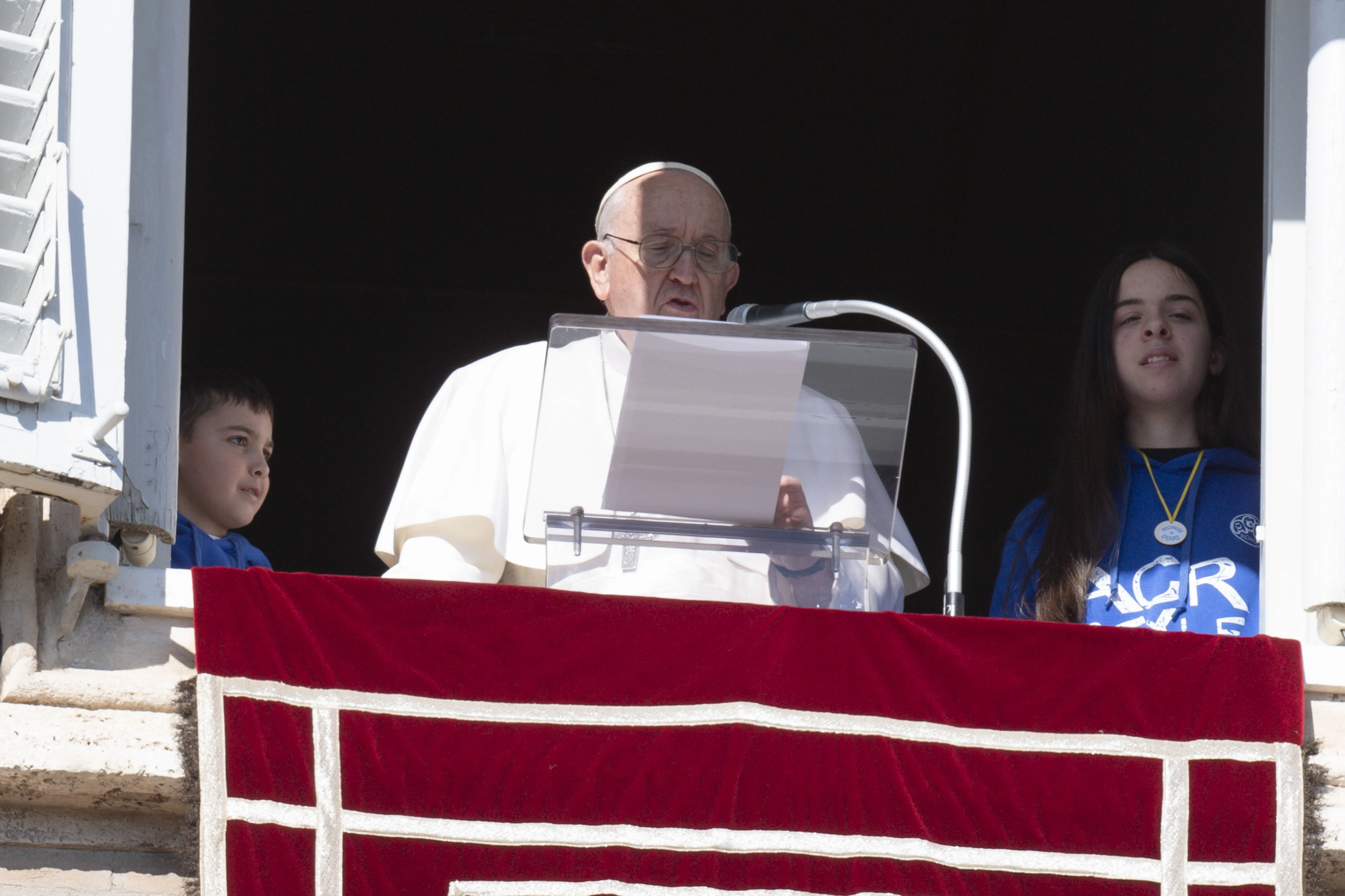 A young boy and girl in blue sweatshirts joined Pope Francis in the window of the Apostolic Palace and read aloud a letter sharing their efforts as part of Catholic Action’s “Caravan of Peace.”. Vatican Media