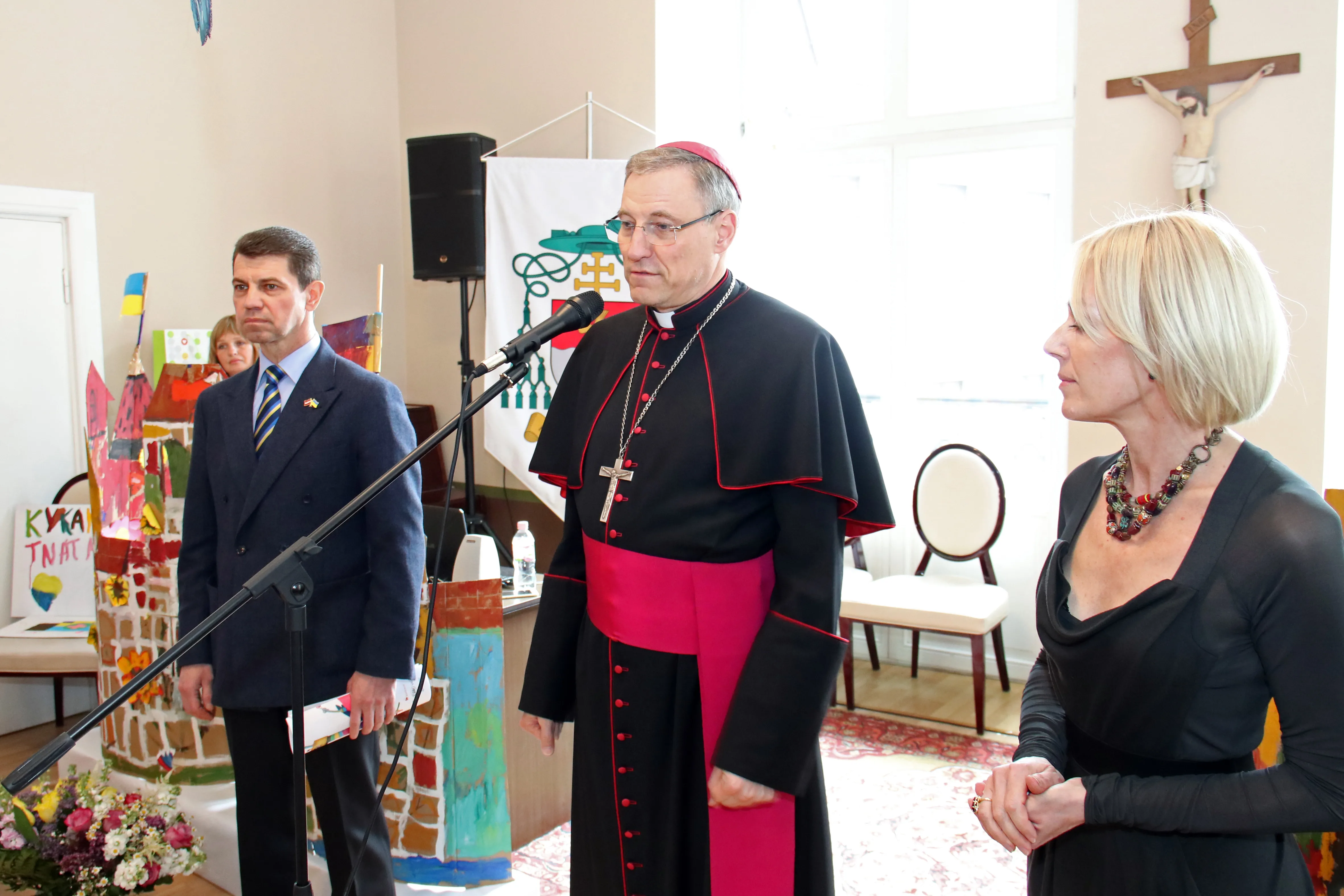 Archbishop Zbigņev Stankevičs gives an opening speech at the exhibition, flanked by Olexandr Mischenko, Ukrainian ambassador to Latvia, and Gabriella Cabiere, curator of the exhibit. Archdiocese of Riga