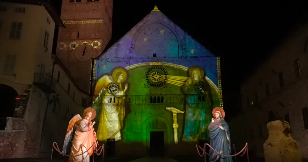 A light projection of Giotto's Annunciation on the Cathedral of San Rufino in Assisi.  Website Screenshot