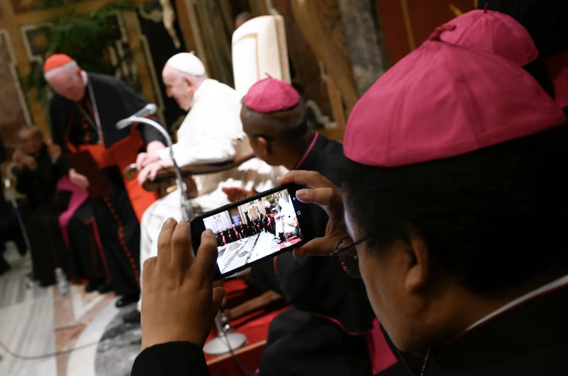 A bishop takes a photo of Pope Francis during their encounter on Sept. 19, 2022. Vatican Media