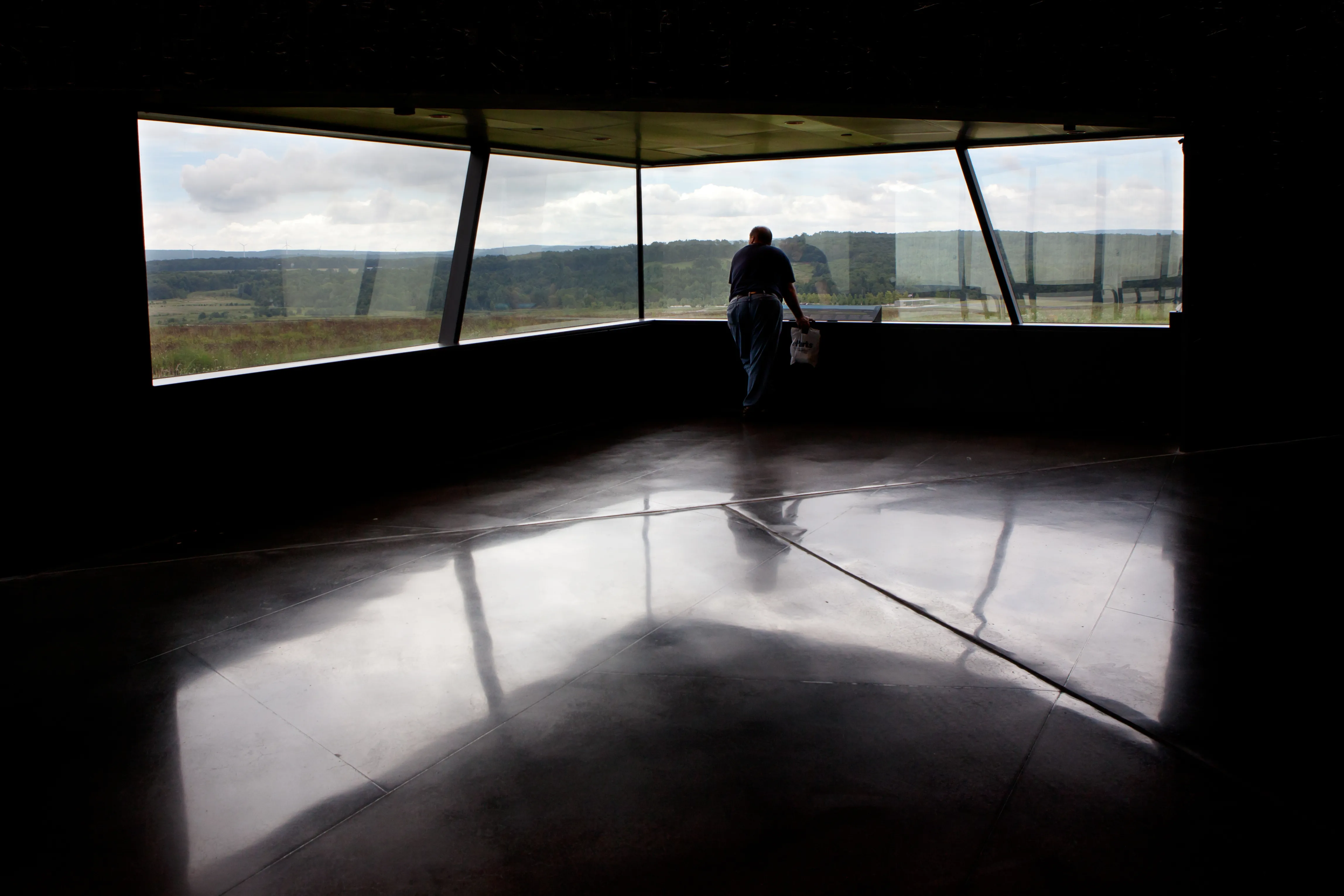 An unidentified man looks through a window at the Flight 93 National Memorial Visitor Center near Shanksville, Pennsylvania on Aug. 17, 2016. The window overlooks the impact site. Shutterstock