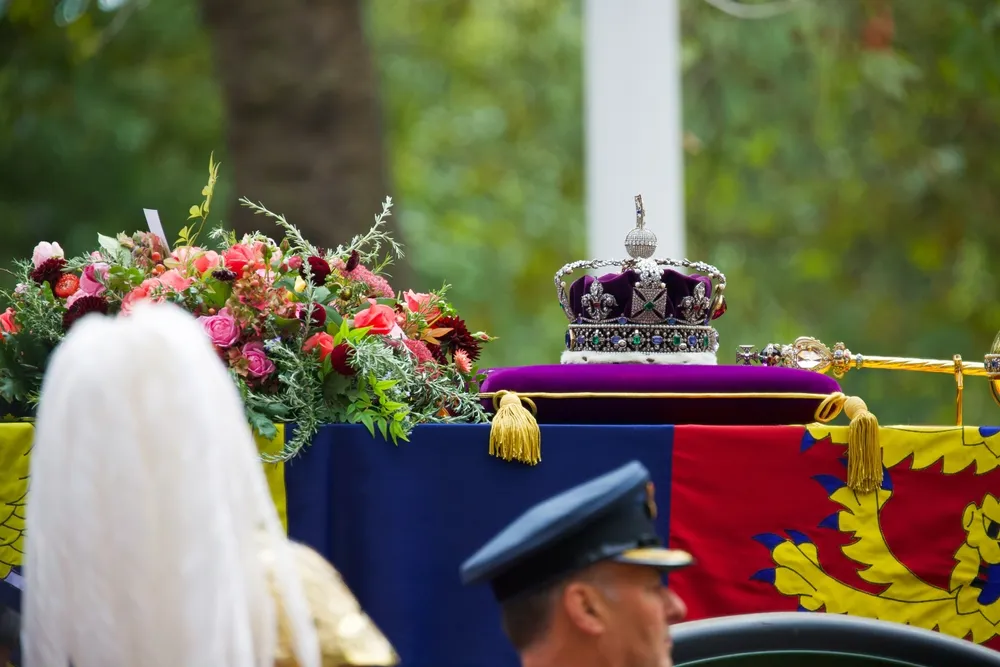 The Imperial State Crown, Sceptre, and wreath of symbolic flowers adorn the coffin of Her Late Majesty Queen Elizabeth II on the gun carriage for the funeral procession, Sept. 19, 2022.?w=200&h=150