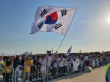 Pilgrims from South Korea wave a flag at Mass with Pope Francis for the closing of World Youth Day 2023 in Lisbon on Aug. 6, 2023.