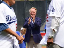 Longtime baseball broadcaster Vin Scully applauds Los Angeles Dodger hall of famers during opening day pre-game ceremonies on April 4, 2014, in Los Angeles, California.