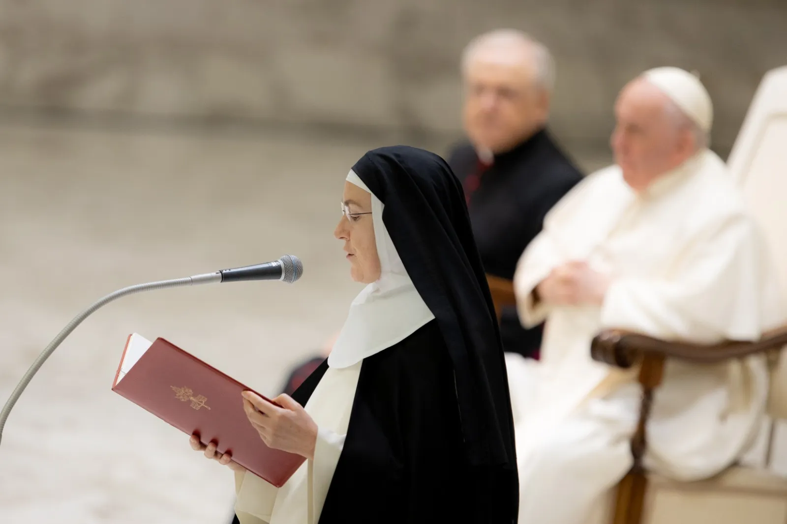 A religious sister reads a translation of the pope's message at his general audience on Feb. 15, 2023. Daniel Ibanez/CNA