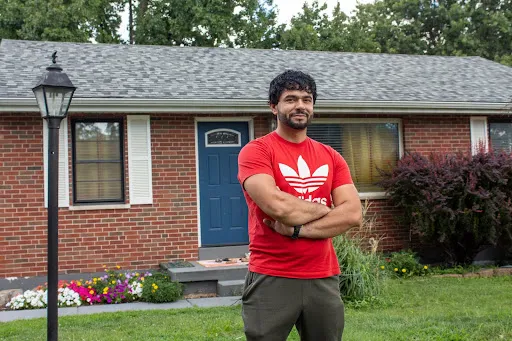 Farid Wardak stands in front of the house that Ann and Frank Wittman purchased for his family in the St. Louis suburb of Affton. Farid, who now works a manufacturing job in nearby Fenton, hopes someday to buy the house from the Wittmans. Jonah McKeown/CNA